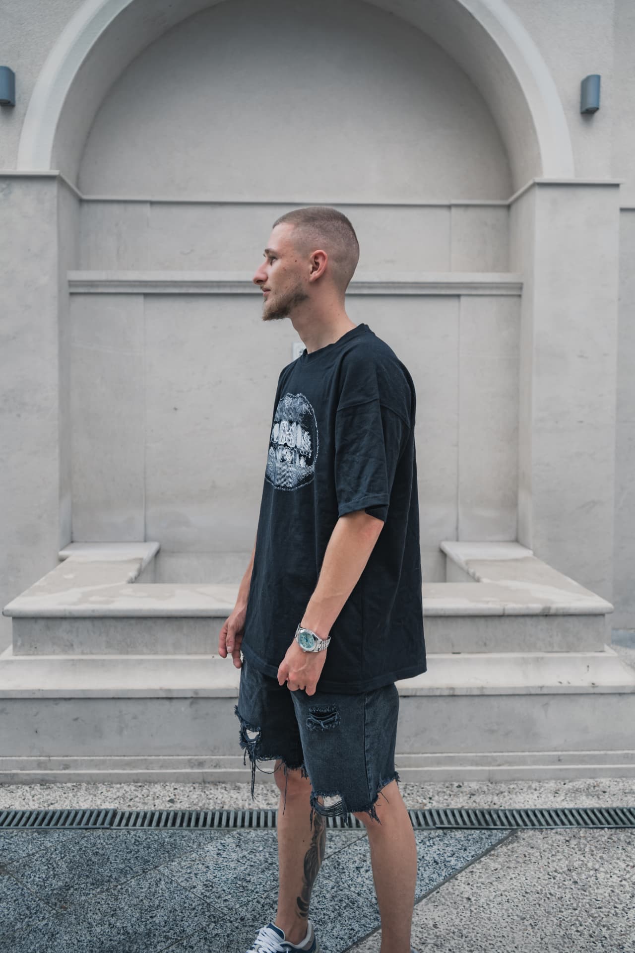 Model in ATRIX Drop 01 tee against a stone archway